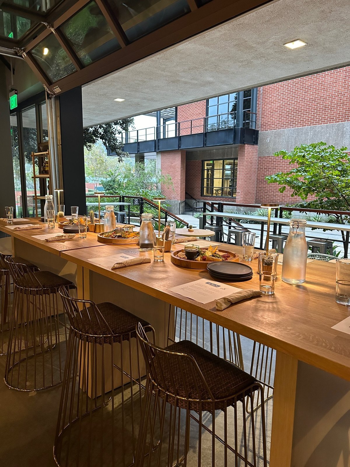 A communal dining table beside the open courtyard at Therapie Bistro